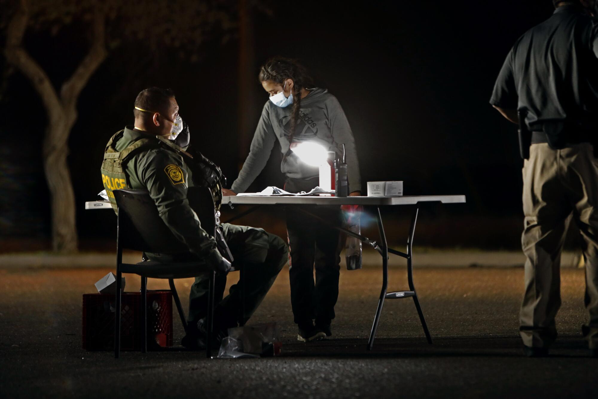 A girl is processed by Border Patrol agents after crossing the border illegally with other juveniles on March 18.