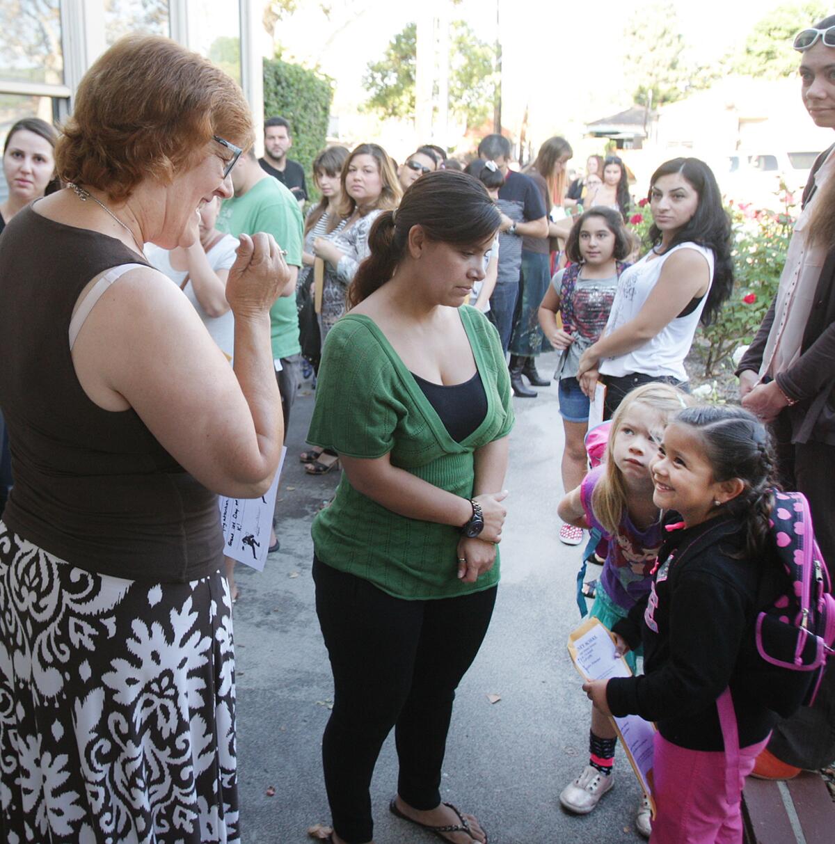 Kindergarten teacher Teresa Sheerer greets two students who will be in her class on the first day of school at Walt Disney Elementary School in Burbank on Monday, August 18, 2014.