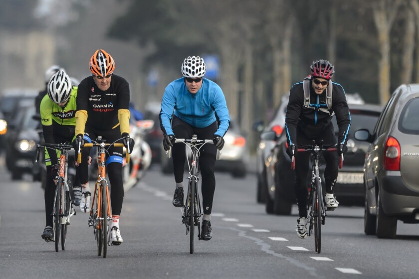 Secretary of State John Kerry, second from left, rides his bicyle in March during talks in Switzerland over Iran's nuclear program. Kerry broke his right leg in a bike accident Sunday, officials said.