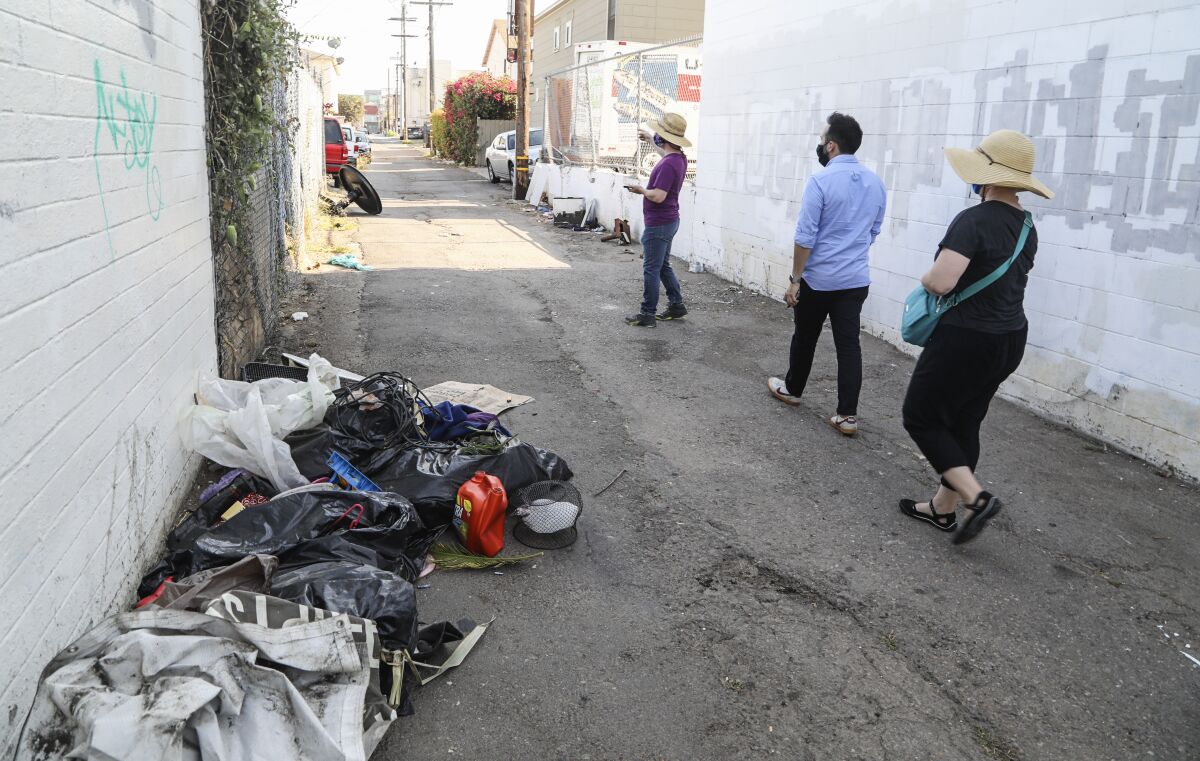James Lively, Christopher Vallejo, and Lydia Bringerud report dumped trash in an alley.