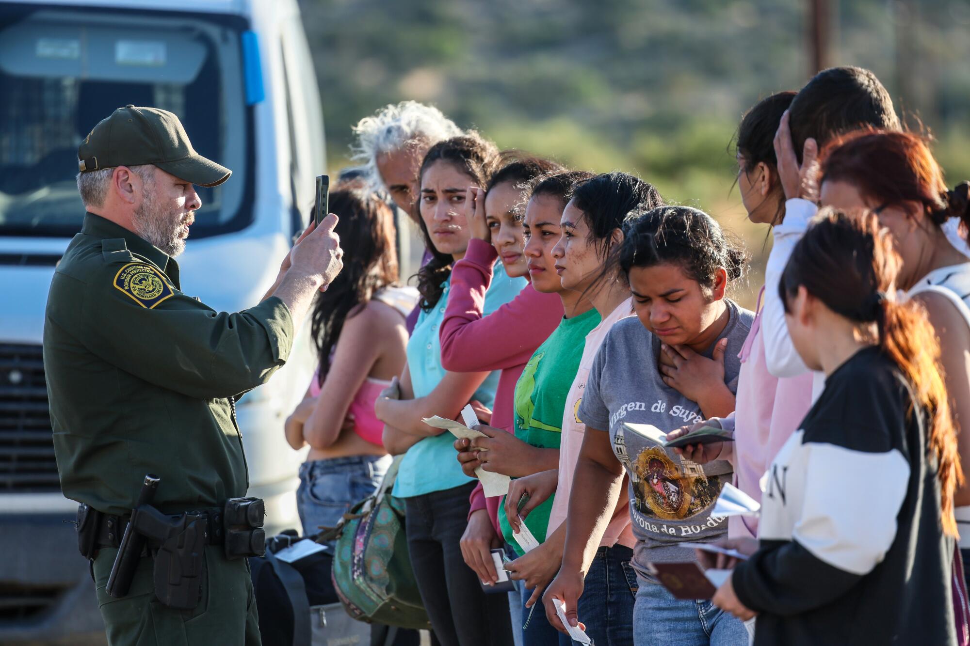 A Border Patrol agent photographs people