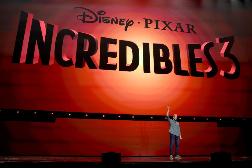 a man on stage standing in front of the 'Incredibles 3' logo