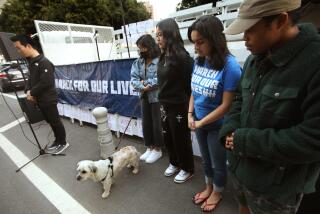 LOS ANGELES, CA - JANUARY 28, 2023 - Youth and community organizers Victor Shi, from left, Shekinah Deocares, Anna Pham, Shaadi Ahmadzadeh and Sim Bilal, participate in a moment of silence in memory of the shooting victims of Monterey Park and Half Moon Bay in front of City Hall in downtown Los Angeles on January 28, 2023. They came together as a part of the national gun violence prevention organization March for Our Lives to honor the recent shooting victims and to demand gun violence prevention legislation from the local level up to the federal. (Genaro Molina / Los Angeles Times)