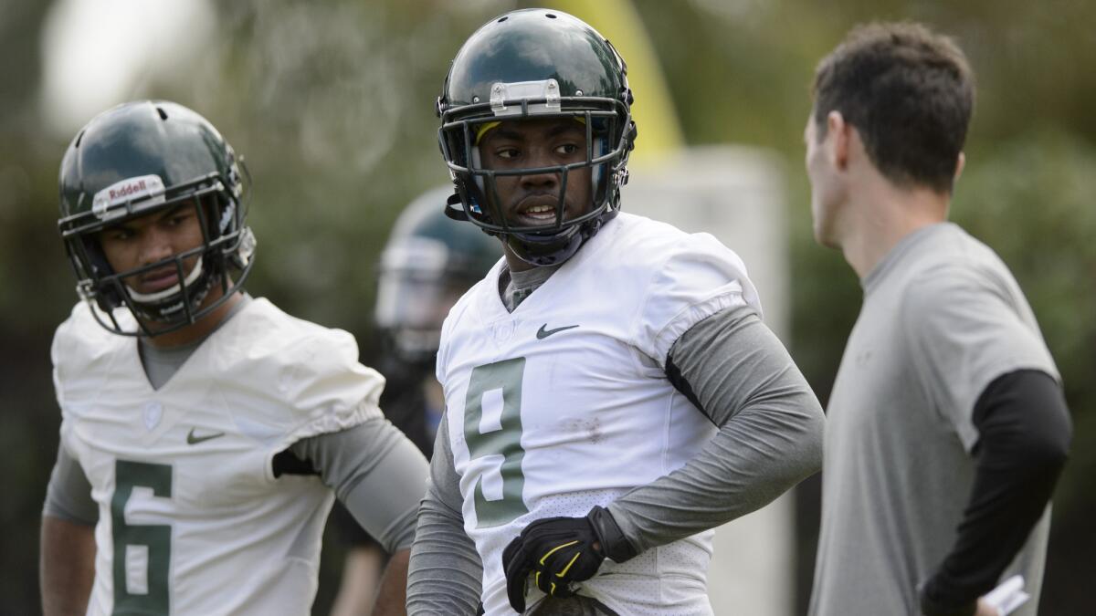 Oregon wide receivers Byron Marshall, center, and Charles Nelson, left, talk with assistant coach John Neal during a team practice in Carson on Tuesday.