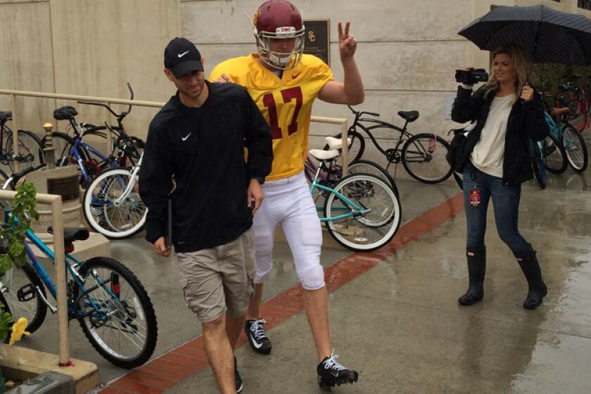 Jake Olson walks to the Trojans practice field on Tuesday.