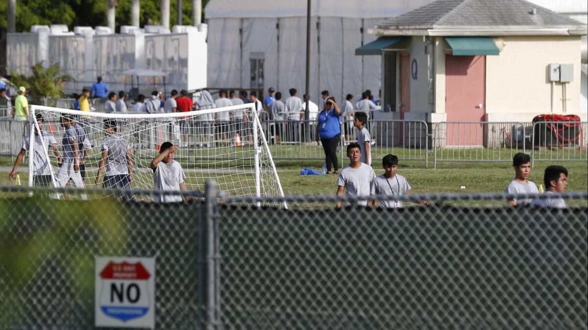 Immigrant children play outside a former Job Corps site that now houses them in Homestead, Fla.