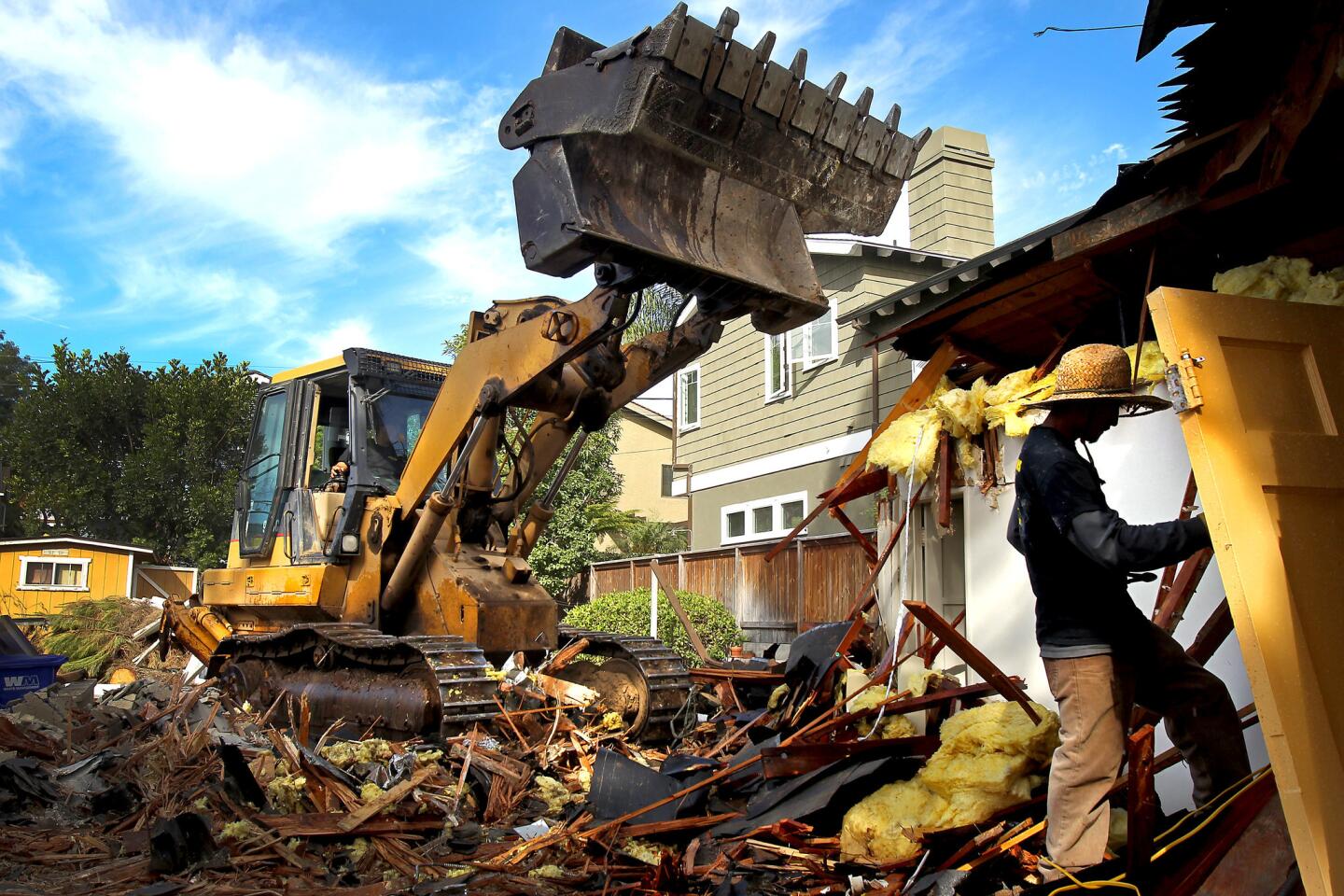 A demolition crew razes a 782-square-foot cottage in Manhattan Beach in October to make way for a 3,300-square-foot Cape Cod mansion.