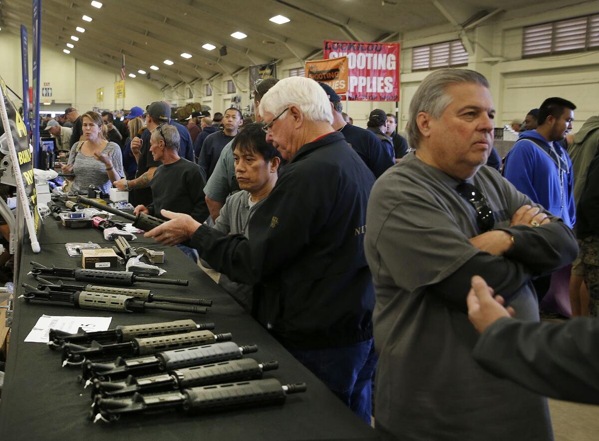 Gun enthusiasts view AR-15 semiautomatic assault rifle upper receiver parts and kits, which are legal in California, at the Crossroads of the West Gun Show in Del Mar, Calif. last year.