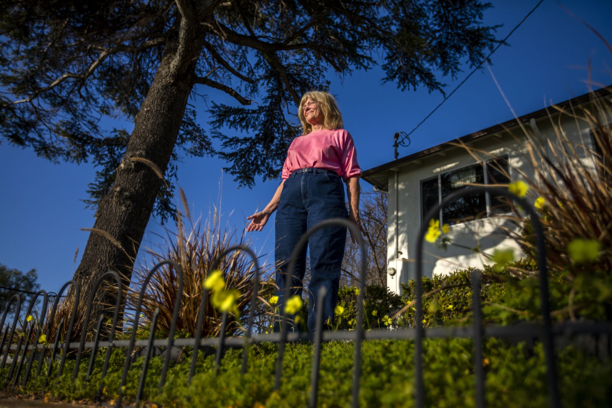 Debbie Frederick, 72, stands in the frontyard of the home she purchased from Caltrans in Hayward.