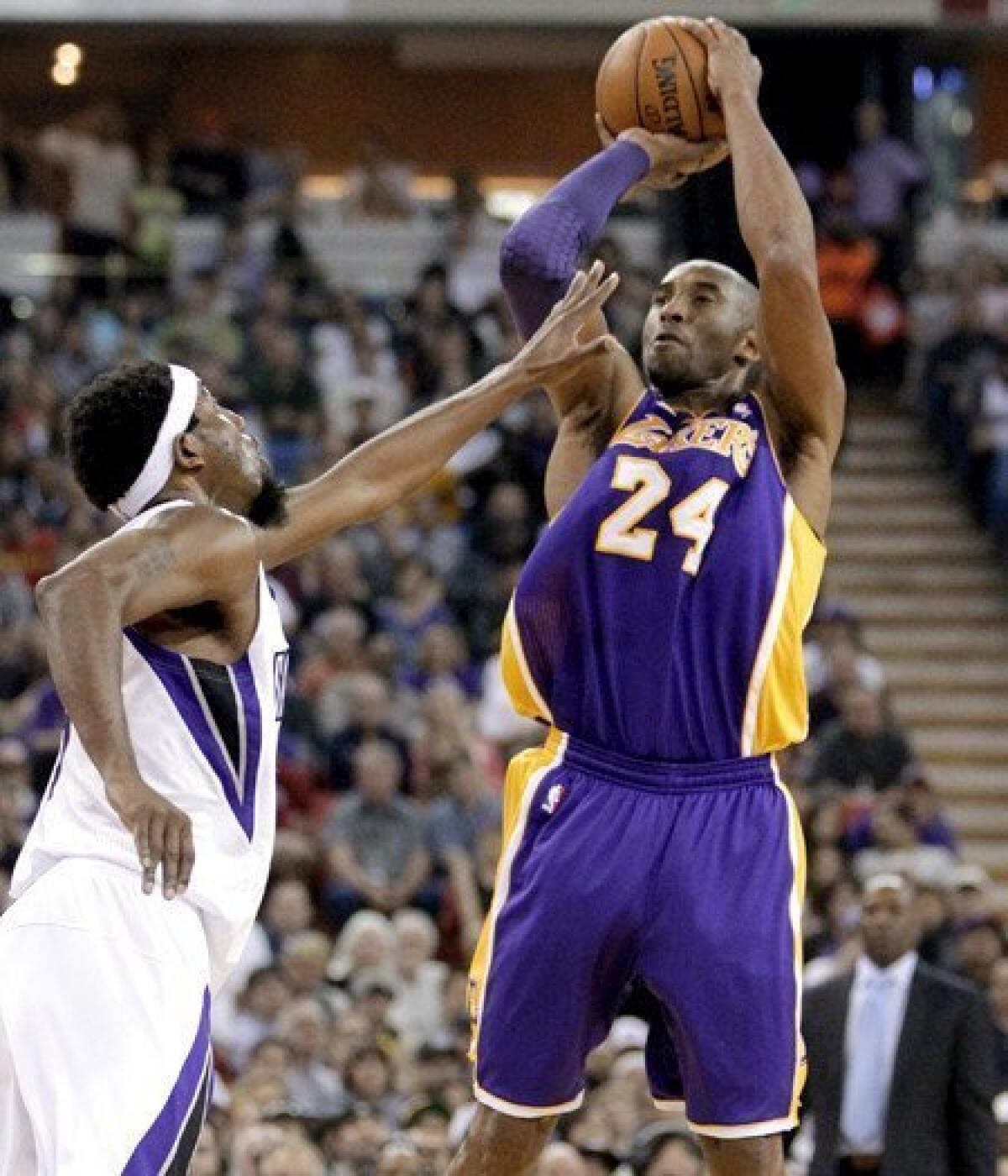 Lakers guard Kobe Bryant pulls up for a jumper over Kings forward John Salmons in the first half Saturday night in Sacramento.
