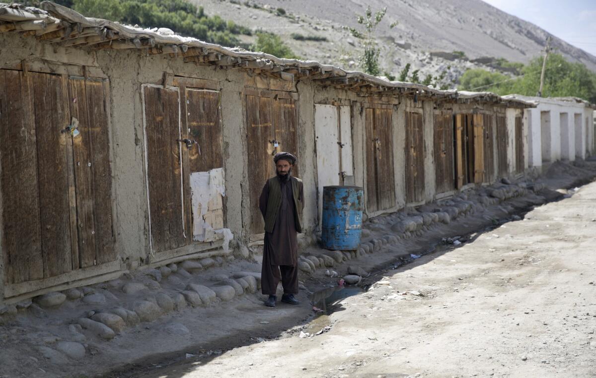 Un aldeano posa junto a negocios cerrados en Qazideh, poblado del Corredor de Wakhan, Afganistán. En esta empobrecida región olvidada del noreste del país no circula la moneda y las pocas transacciones comerciales que se hacen son a base de permiutas. Pero los negocios permanecen cerrados buena parte del tiempo. (AP Photos/Massoud Hossaini)