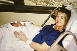 Kathryn Laing holding her twin newborns, Kevin and Shey Sabellico.