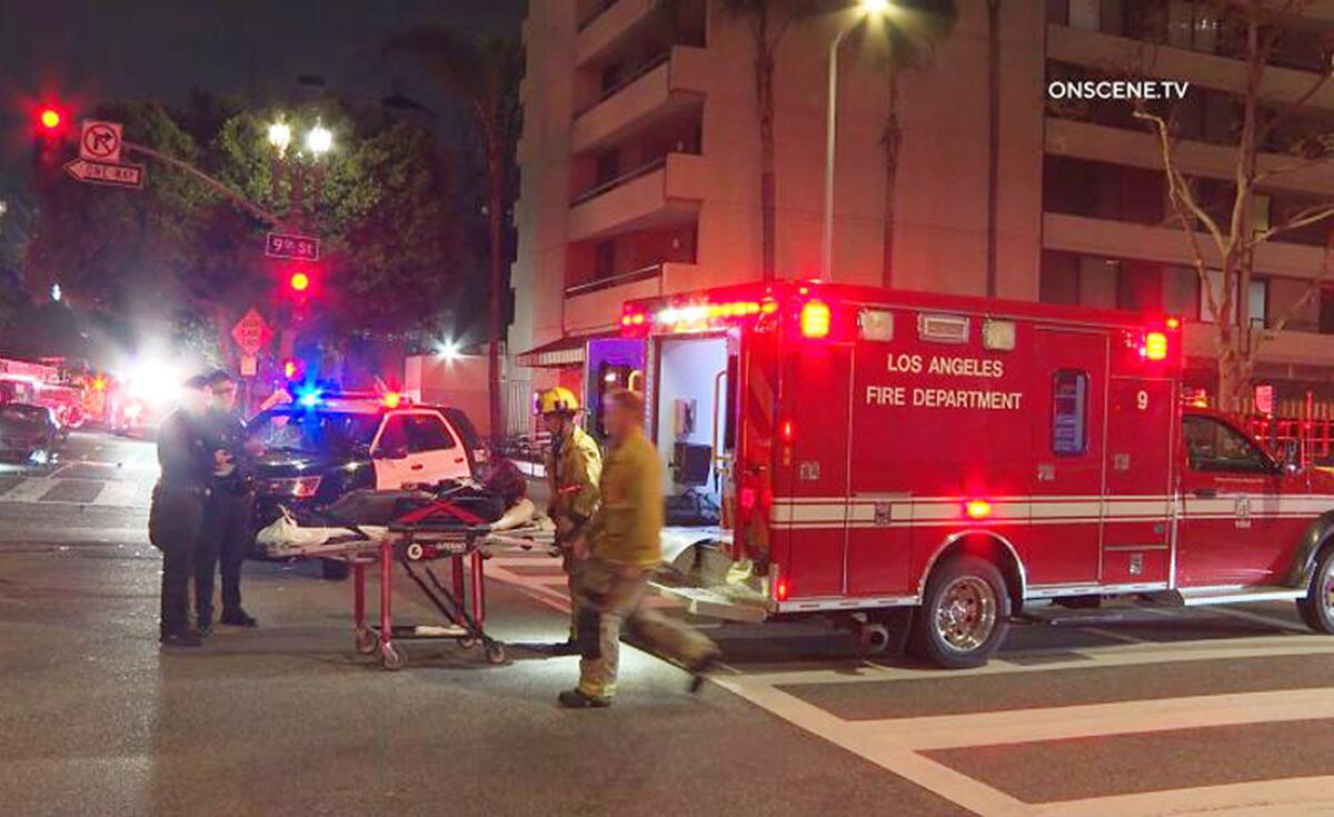 Firefighters load someone into the back of a Los Angeles Fire Department ambulance