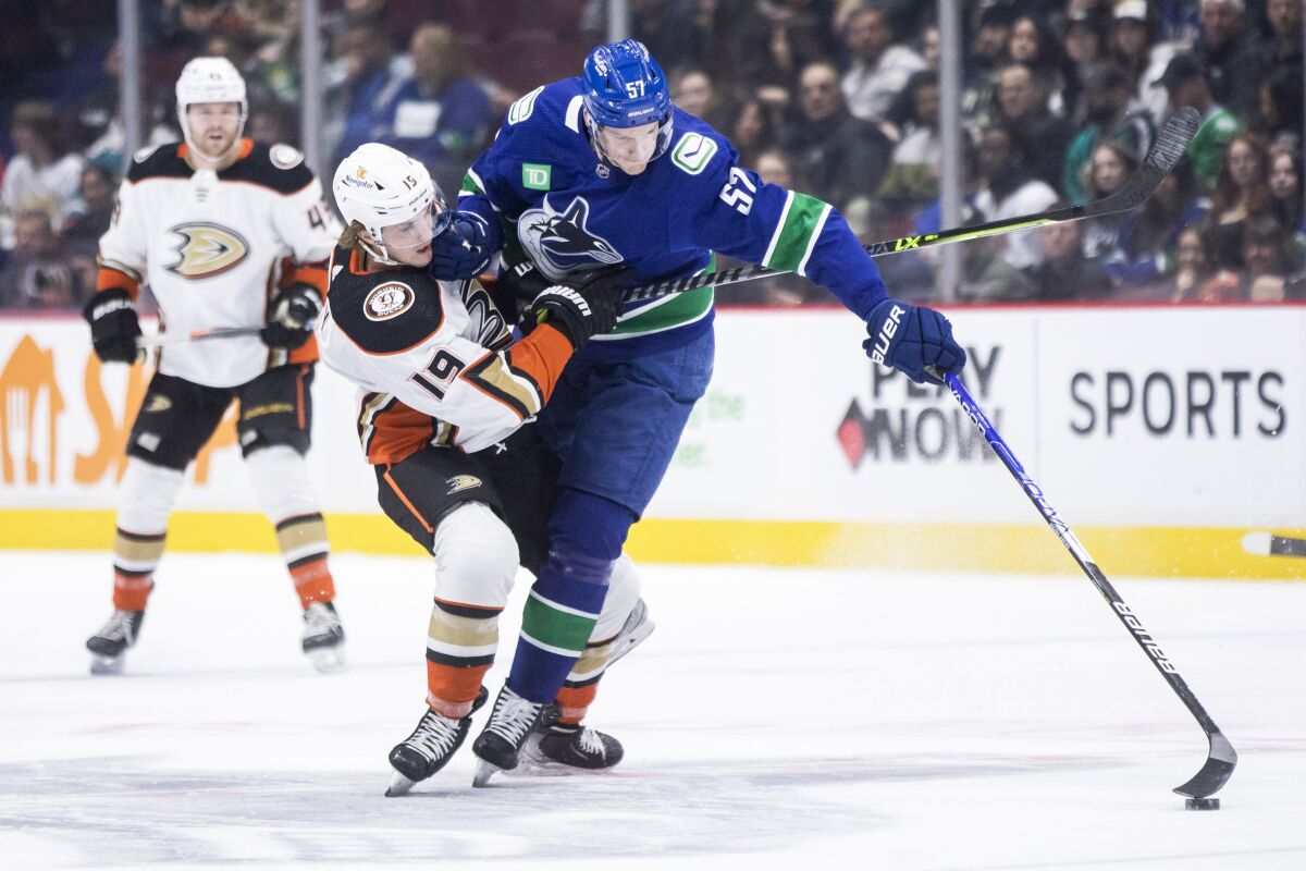 Ducks' Troy Terry is checked by Vancouver Canucks' Tyler Myers during the first period.