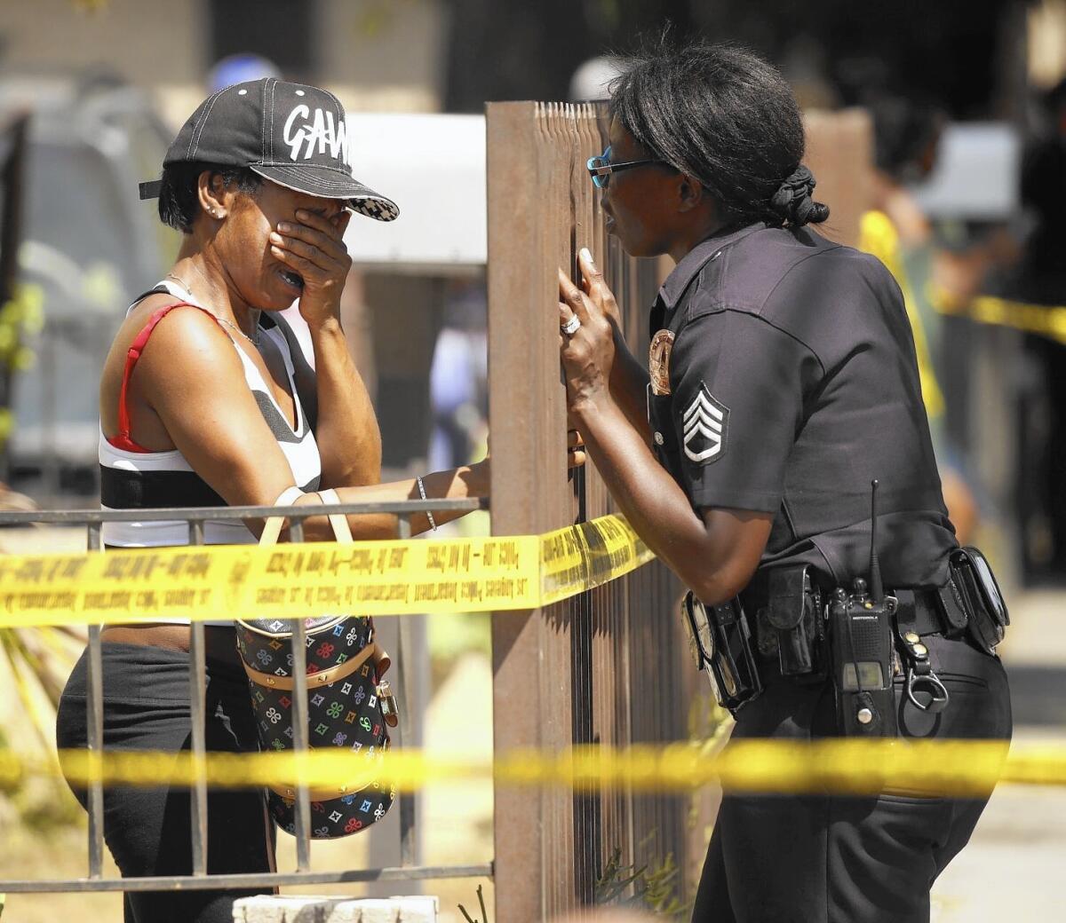 LAPD Sgt Emada Tingirides, right, talks to the sister of a homicide victim.
