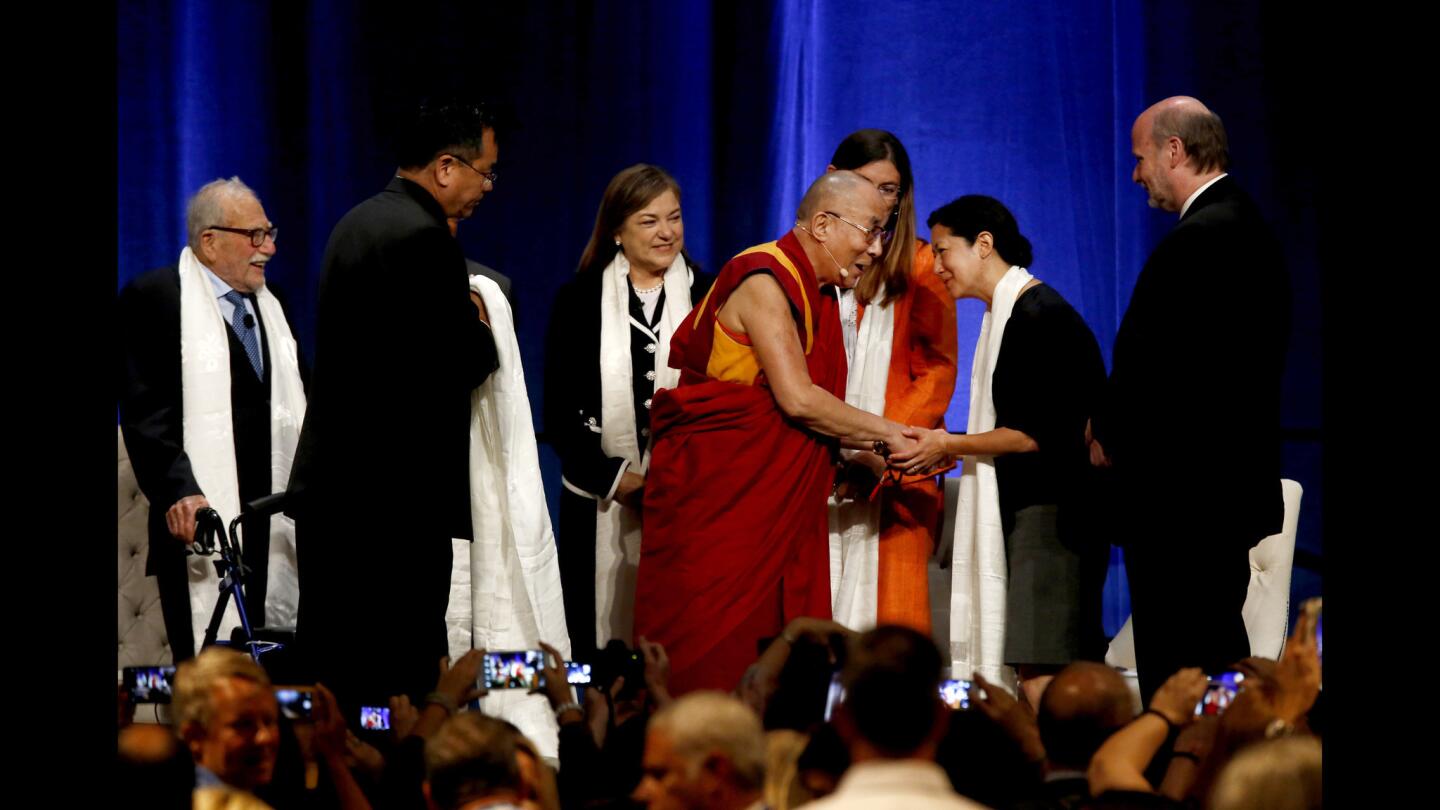 The Dalai Lama greats Miya Yoshitani, executive director of the Asia Pacific Environmental Network, after participating in a climate change panel discussion in Irvine on July 6.