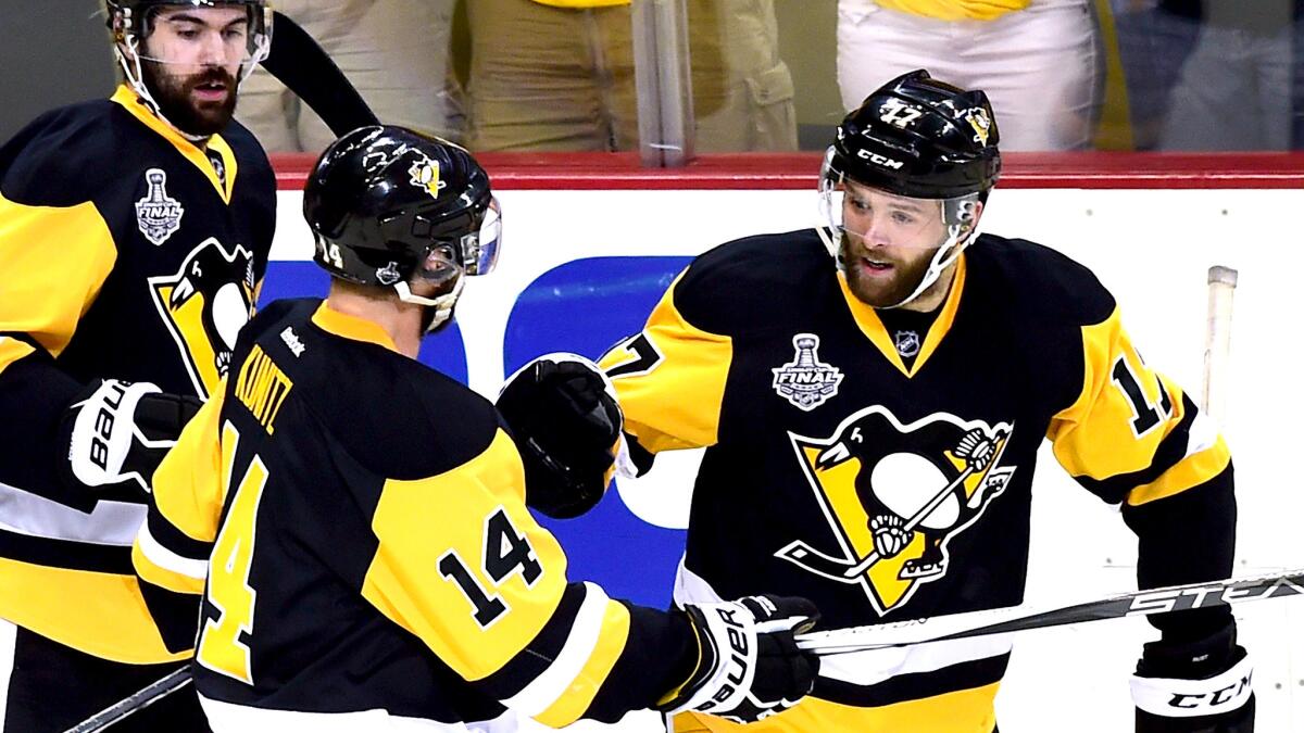 Penguins right wing Bryan Rust (17) celebrates a goal against the Sharks with teammates Chris Kunitz (14) and Justin Schultz.