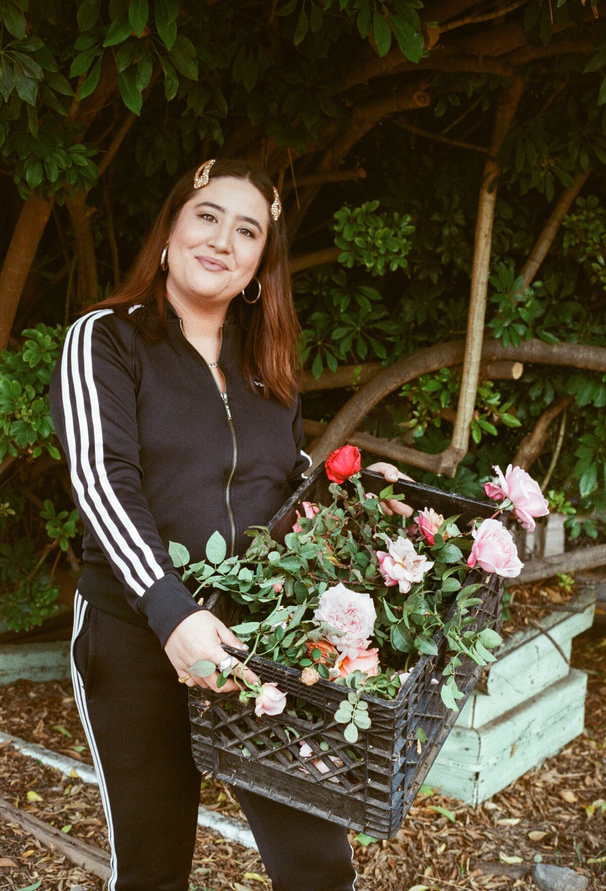 Floral designer Alex Floro carries a crate full of flowers