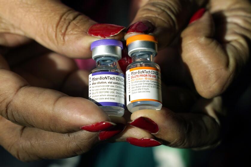 A nurse holds a vial of the Pfizer COVID-19 vaccine for children ages 5 - 11, right, and a vial of the vaccine for adults, which have different colored labels, at a vaccination station in Jackson, Miss., Tuesday, Feb. 8, 2022. Pfizer’s COVID-19 vaccine gave children 5 and older strong protection against hospitalization and death even during the omicron surge that hit youngsters especially hard, according to new data from the Centers for Disease Control and Prevention released on Tuesday, March 1, 2022. (AP Photo/Rogelio V. Solis)