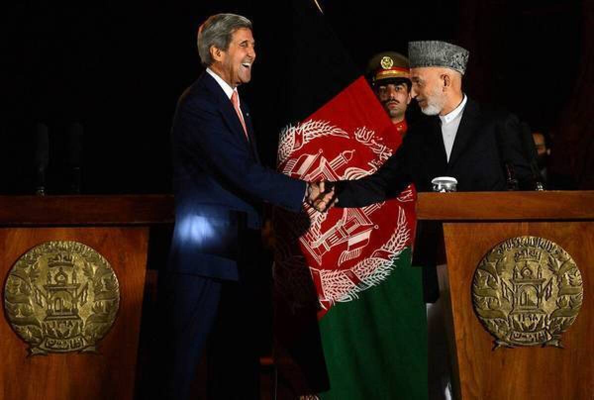 U.S. Secretary of State John F. Kerry greets Afghan President Hamid Karzai during their joint news conference after their talks in Kabul, the Afghan capital.