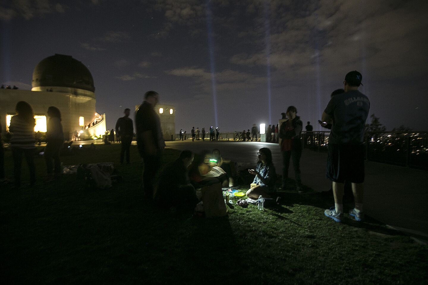 Spotlights illuminate the Los Angeles Marathon route Friday as people picnic at Griffith Observatory.