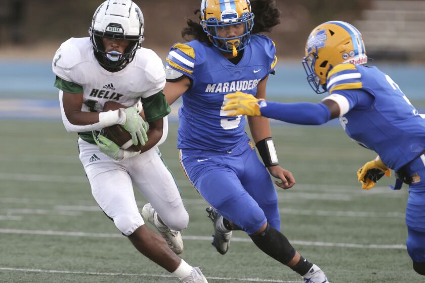 SAN DIEGO CA - AUGUST 19, 2022: Helix's Randy Evans carries the ball Sy Fanua, center, and Makei Thompson pursue him during the first quarter at Mira Mesa High School in San Diego on Friday, August 19, 2022. (Hayne Palmour IV / For The San Diego Union-Tribune)