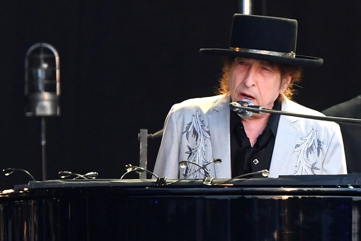 Bob Dylan singing at a piano