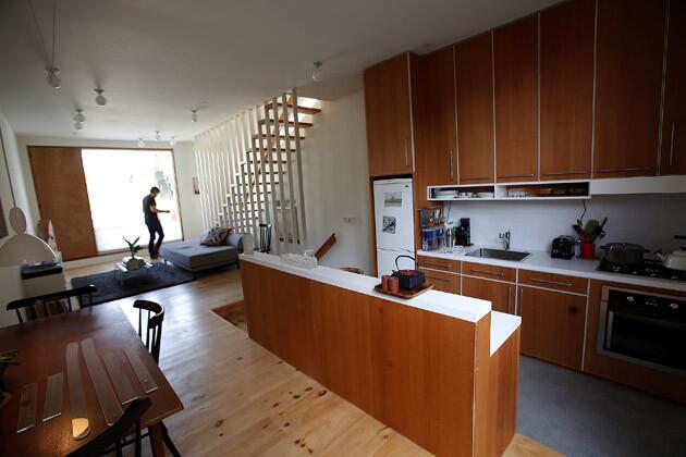 The view from the rear of the house of the living room, kitchen and dining area. Storey designed the sunken kitchen himself, calling it "an experiment in materials." He used Douglas fir for the cabinetry, concrete for the floor and Formica for the countertops.