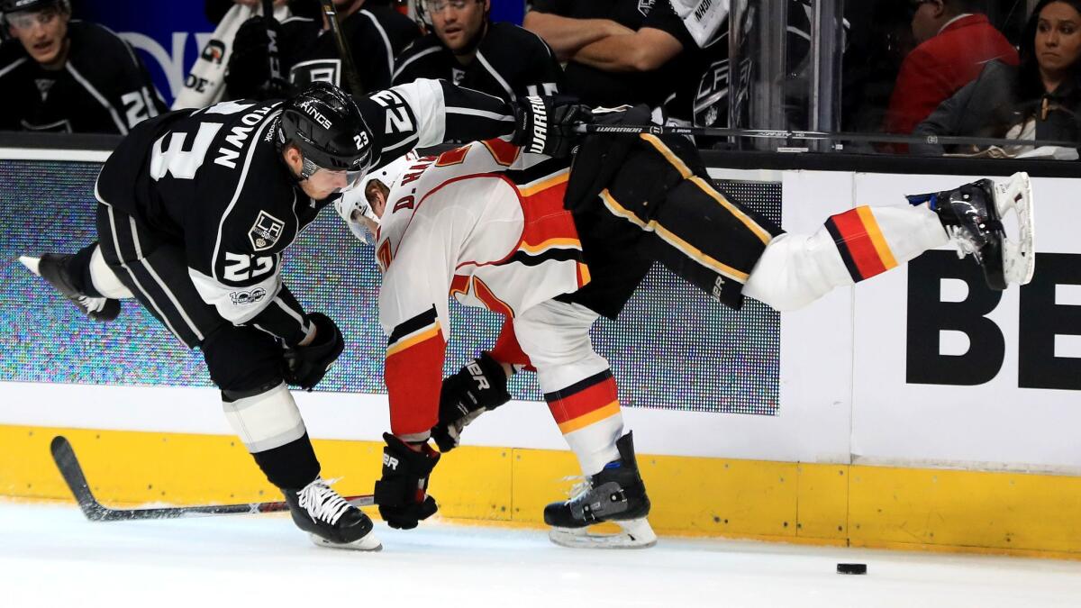 Kings' Dustin Brown checks Calgary's Dougie Hamilton on April 6 at Staples Center.