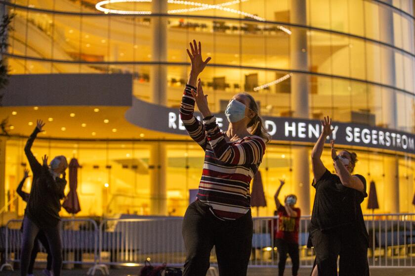 Jeanne Franco, center, and other participants work on choreography from Chicago during a Tuesday Night Dance class at the Segerstrom Center for the Arts Argyros Plaza. The Broadway-style dance classes are offered every Tuesday night in March.