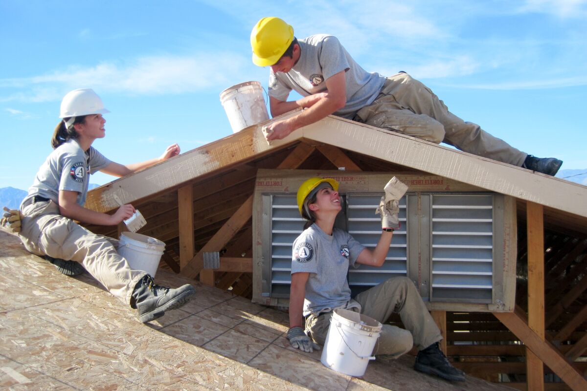 AmeriCorps volunteers work on a roof project.