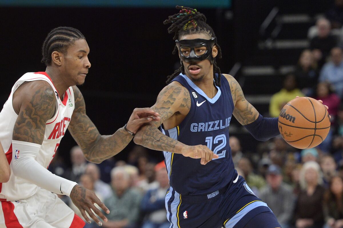 Memphis Grizzlies guard Ja Morant (12) handles the ball against Houston Rockets guard Kevin Porter Jr. (3) in the second half of an NBA basketball game Wednesday, March 22, 2023, in Memphis, Tenn. (AP Photo/Brandon Dill)
