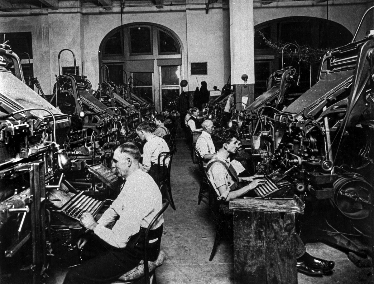 Rows of men sitting at linotype machines