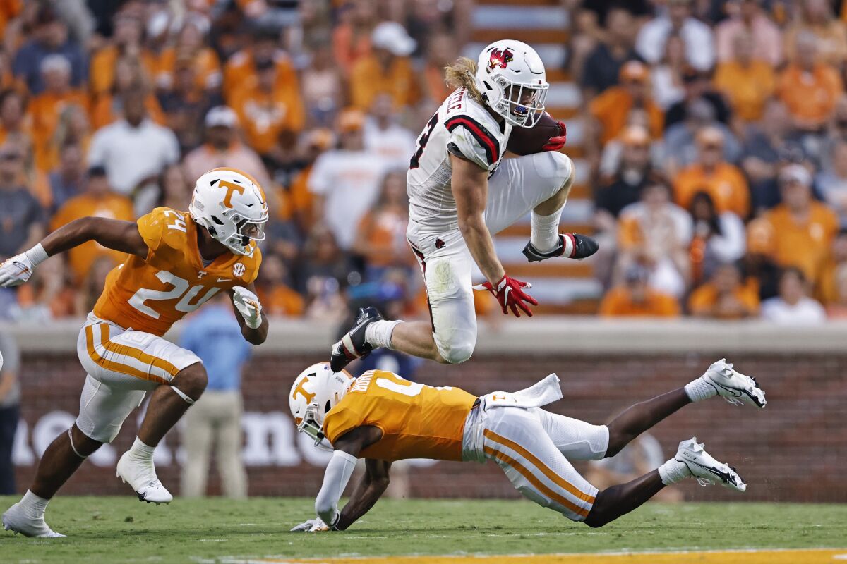 Ball State'den Carson Steele, defans oyuncusu Aaron Beasley tarafından kovalanırken Tennessee defans oyuncusu Warren Burrell'in üzerinden atlıyor.