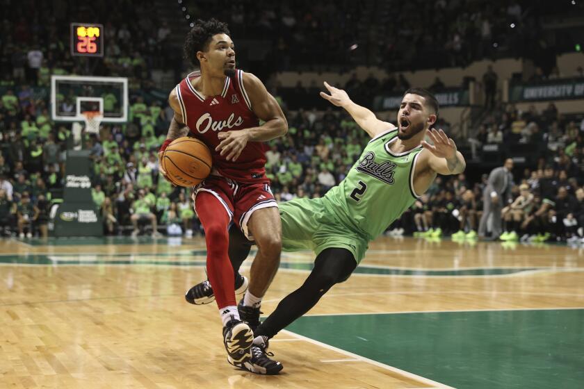Florida Atlantic guard Nick Boyd drives to the basket against South Florida guard Jose Placer during the second half of an NCAA college basketball game Sunday, Feb. 18, 2024 in Tampa, Fla. (AP Photo/Scott Audette)