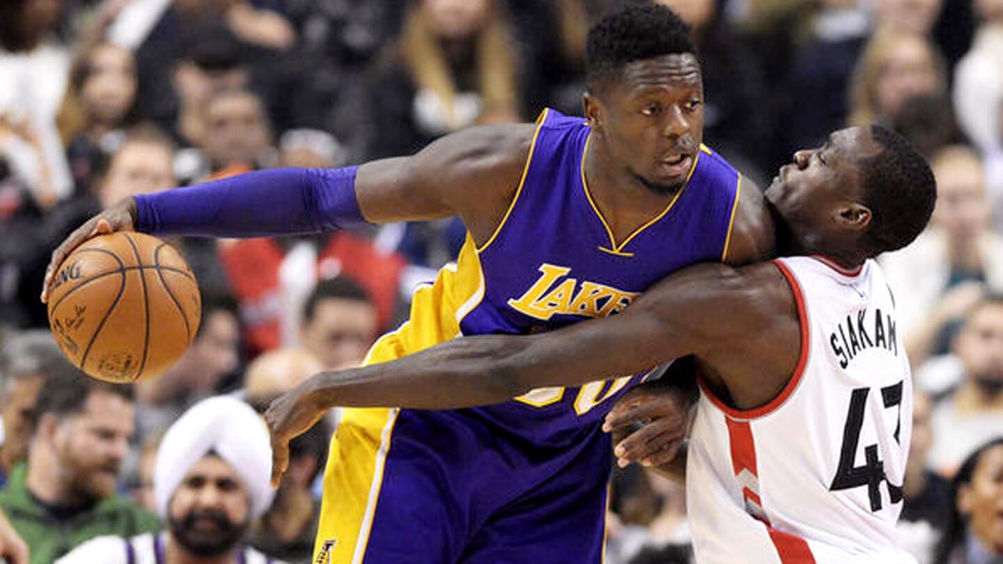 Los Angeles Lakers forward Julius Randle (30) protects the ball from Toronto Raptors forward Pascal Siakam (43) during the first half of an NBA basketball game in Toronto on Friday, Dec. 2, 2016. (Frank Gunn/The Canadian Press via AP)
