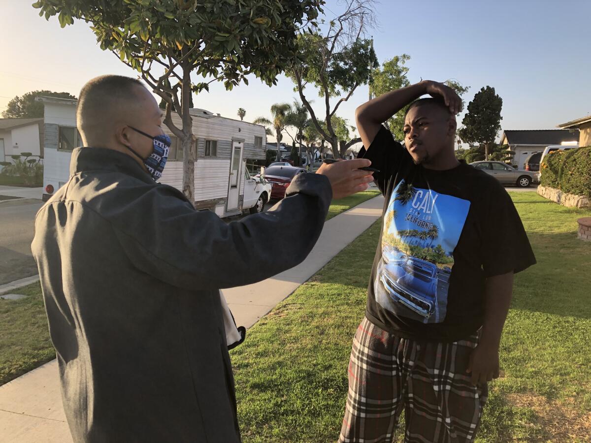 Two men talk in a residential neighborhood.