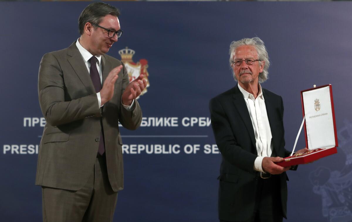 Austrian author Peter Handke, right, receives the Order of the Karadjordje's Star from Serbian President Aleksandar Vucic in Belgrade, Serbia, Sunday, May 9, 2021. Serbia has decorated Austrian Nobel literature laureate Peter Handke, who is known for his apologist views over Serb war crimes during the 1990s' wars in the Balkans. (AP Photo/Darko Vojinovic)