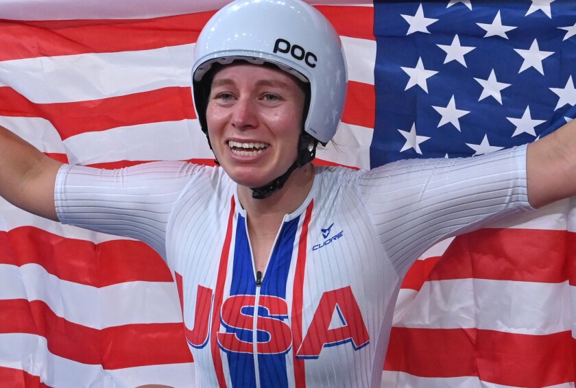 USA's Jennifer Valente poses with flag after winning women's track cycling omnium points race on final day of Tokyo Olympics.