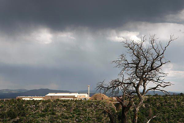 Sunlight peeks through the clouds above the Los Alamos Neutron Science Center, part of the Los Alamos National Laboratory. More than 60 years after the lab's scientists assembled the nuclear bombs dropped on Japan during World War II, lethal waste is seeping out of mountain burial grounds and moving toward drinking water sources.