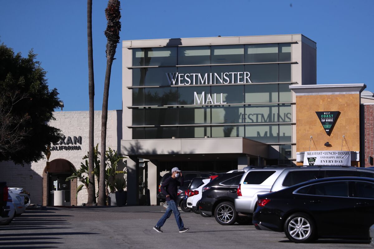 Shoppers walk through the parking lot at Westminster Mall in February.
