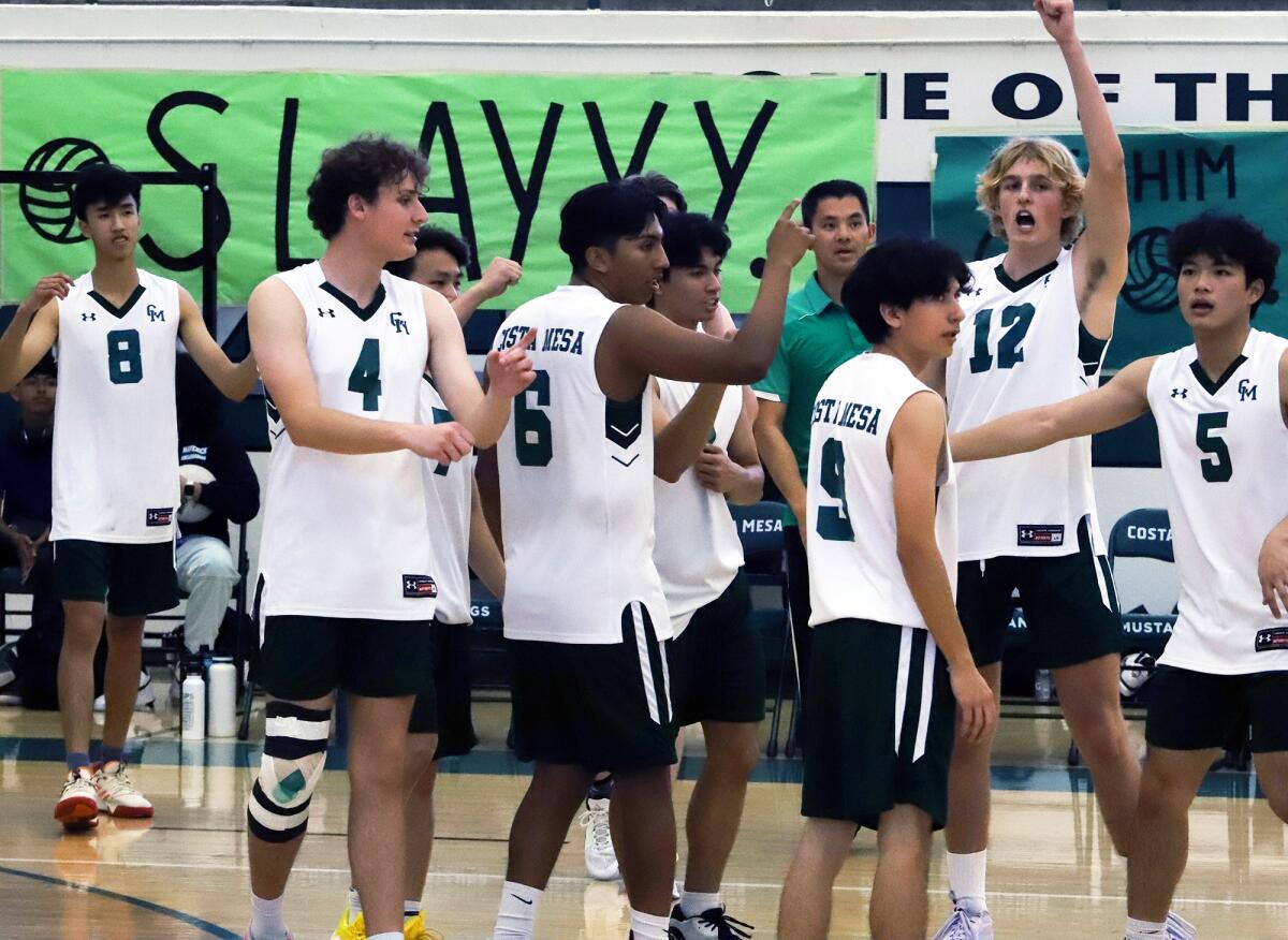 The Costa Mesa boys' volleyball team celebrates after winning against Estancia in the Battle for the Bell on Tuesday.