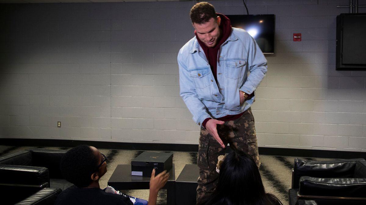 Clippers forward Blake Griffin spends moment with Lucas and Morales who are the recipients of eye glasses donated by Griffin.