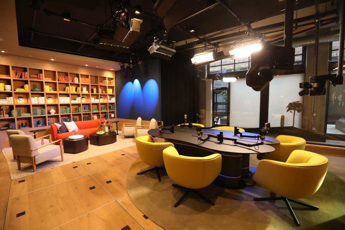 A library-like room outfitted with microphones and studio lighting.