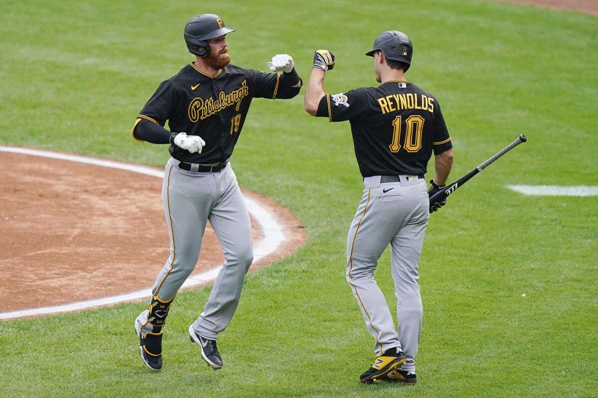Pittsburgh Pirates' Colin Moran (19) celebrates with teammate Bryan Reynolds (10) after hitting a home run in the first inning of a baseball game against the Cincinnati Reds at Great American Ballpark in Cincinnati, Thursday, Aug. 13, 2020. (AP Photo/Bryan Woolston)
