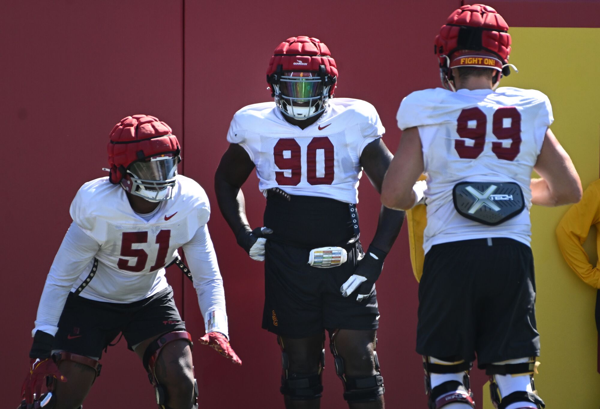 USC defensive lineman Bear Alexander stands beside two teammates during football practice