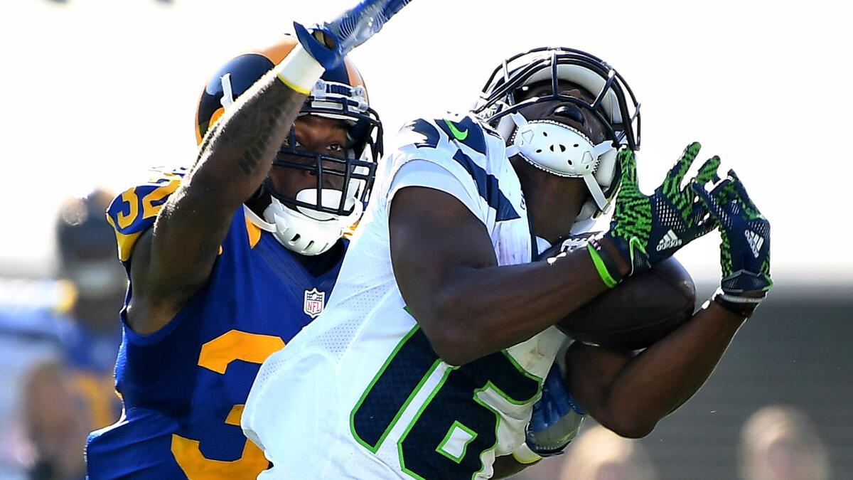 Rams cornerback Troy Hill tries to break up a deep pass to Seahawks receiver Tyler Lockett during their game last month.