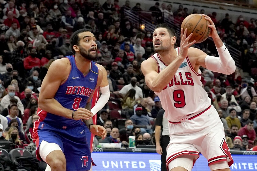 Chicago Bulls' Nikola Vucevic (9) drives to the basket past Detroit Pistons' Trey Lyles during the second half of an NBA basketball game Tuesday, Jan. 11, 2022, in Chicago. The Bulls won 133-87. (AP Photo/Charles Rex Arbogast)