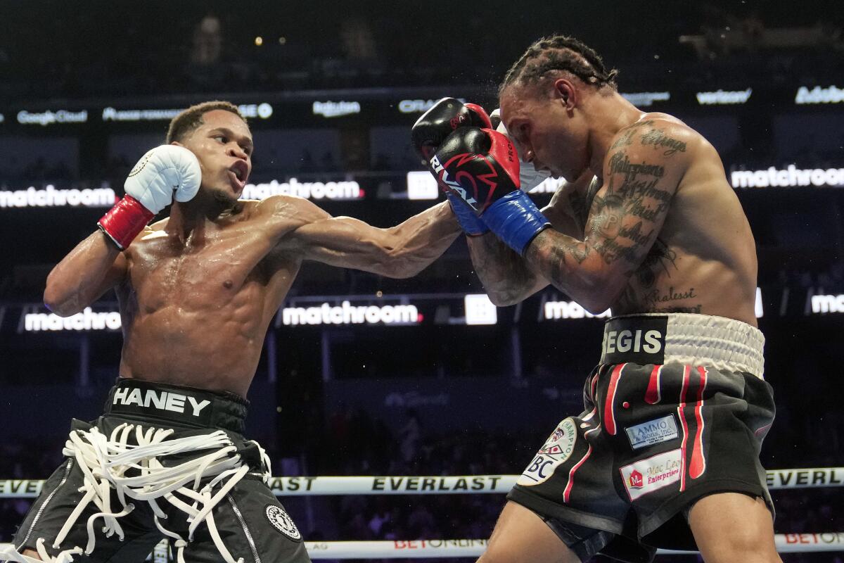 Devin Haney, left, lands a punch to Regis Prograis' face during their WBC super lightweight title fight Saturday.