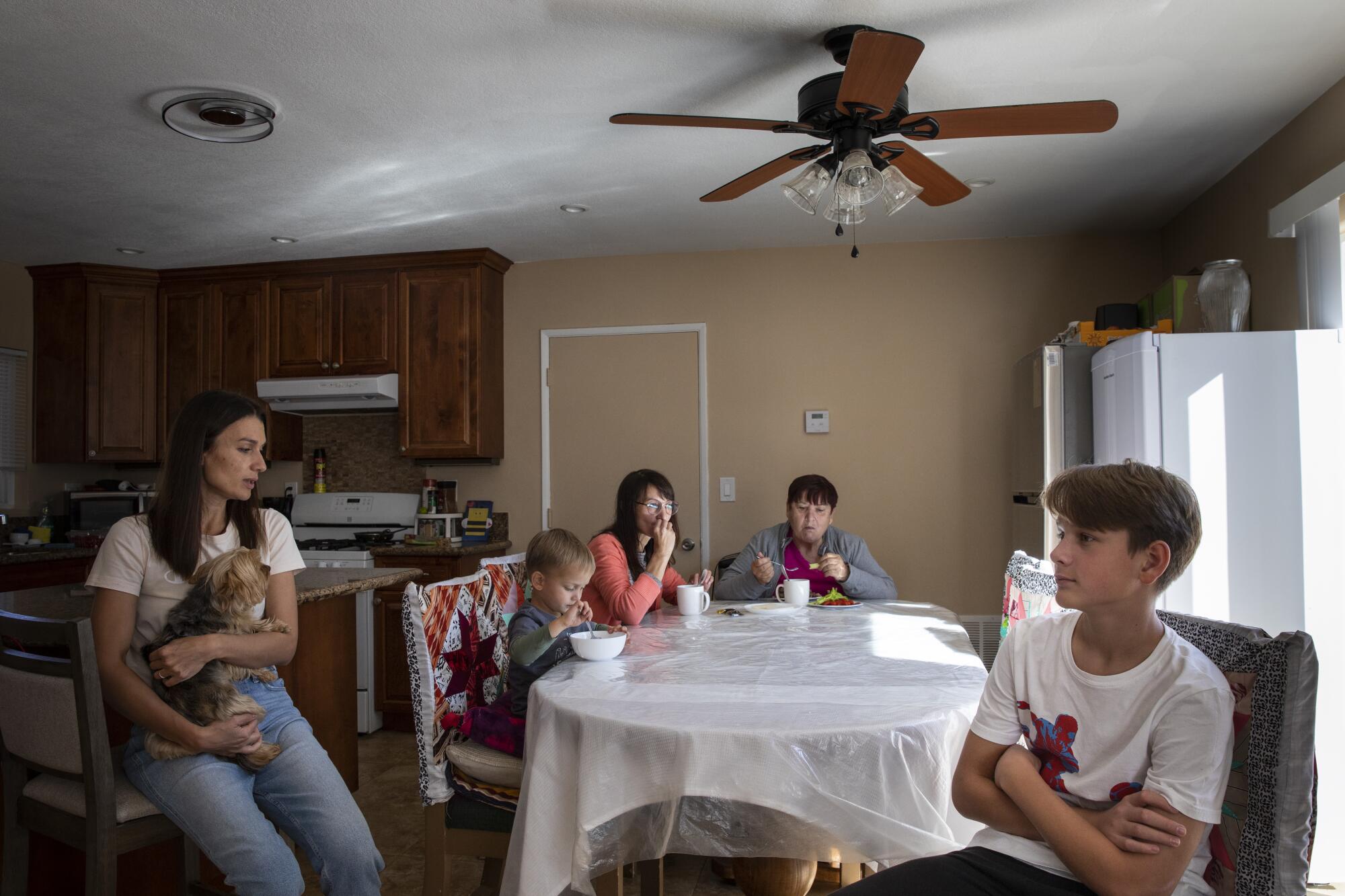Family members sit around a kitchen table